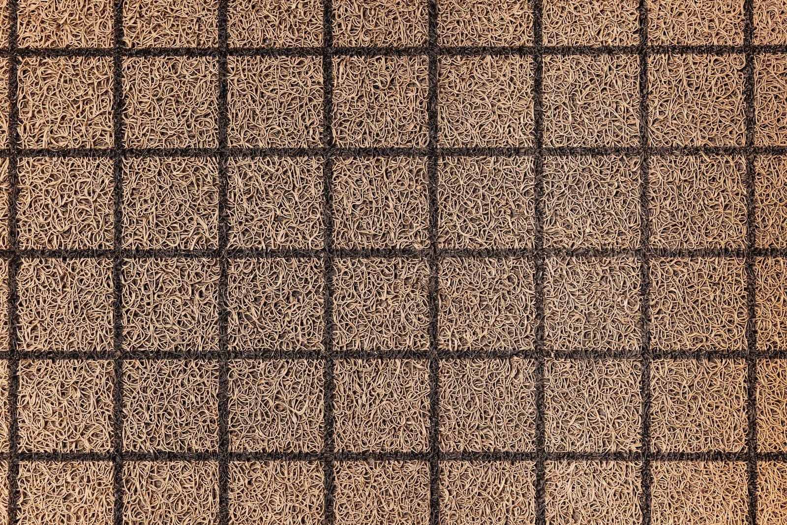Overhead view of a coir walk-off mat with a moulded grid
