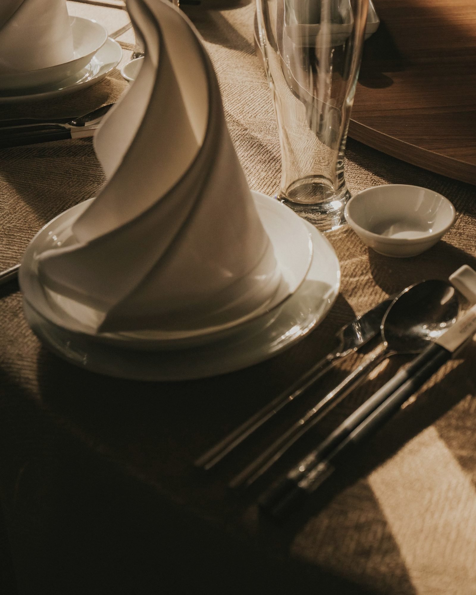 A sculpted white napkin standing on stacked plates